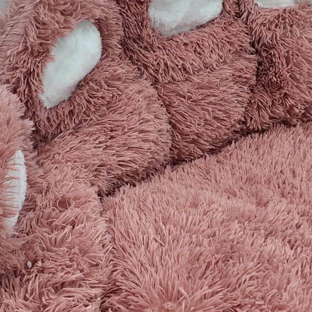 Close-up of a fluffy pink Bear Paw Shape Plush Pet Nest Sofa Bed with a soft texture